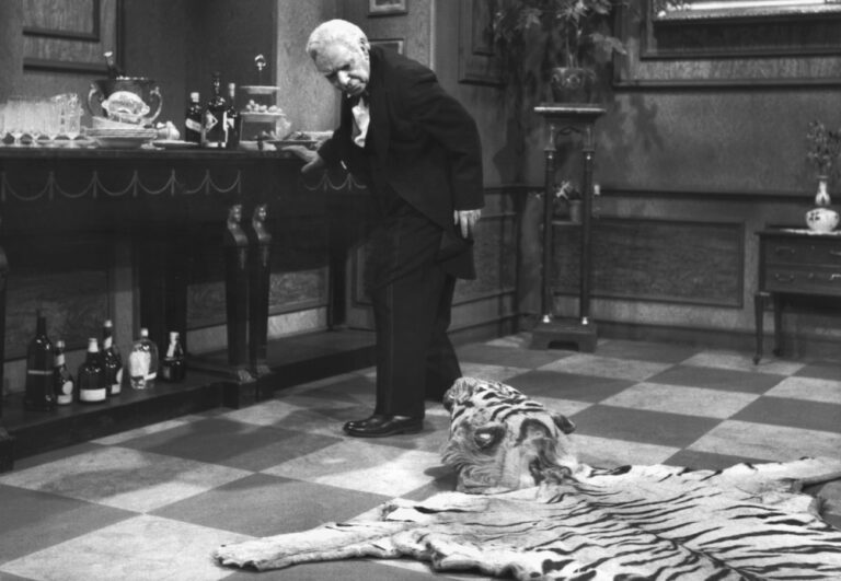 Butler James, gespielt von Freddie Frinton, schaut missbilligend zu dem auf dem Boden liegenden Tigerfell, das eine staendige Stolperfalle auf dem Weg von und zur Anrichte ist. (KEYSTONE/epa/DPA/NDR/Str)
