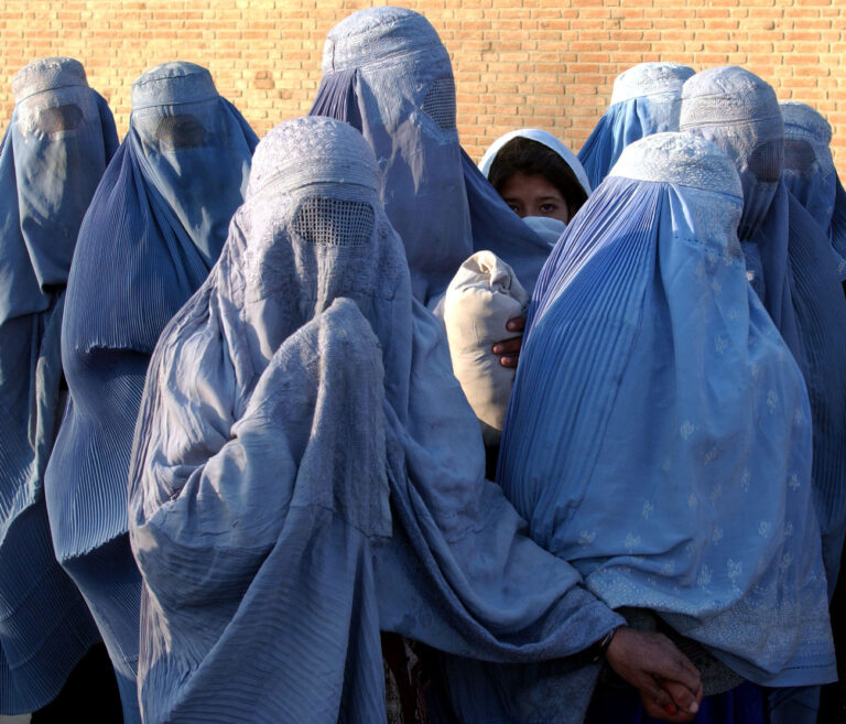 Afghan women, dressed in traditional burkas wait for the United Nations World Food Program to distribute food aid in Kabul, Thursday, Dec 27, 2001. WFP has been distributing food aid for several weeks since the Taliban left Kabul on Nov. 12, 2001.(AP Photo/Marco Di Lauro)