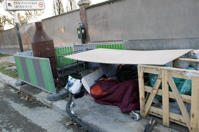 Two homeless men take a nap under their shelter in the streets of Paris, Wednesday, Dec. 16, 2009. A homeless person was found dead Tuesday in Bordeaux, southwestern France, as freezing temperatures dropped to -10 Celsius in the French capital. (AP Photo/Francois Mori)