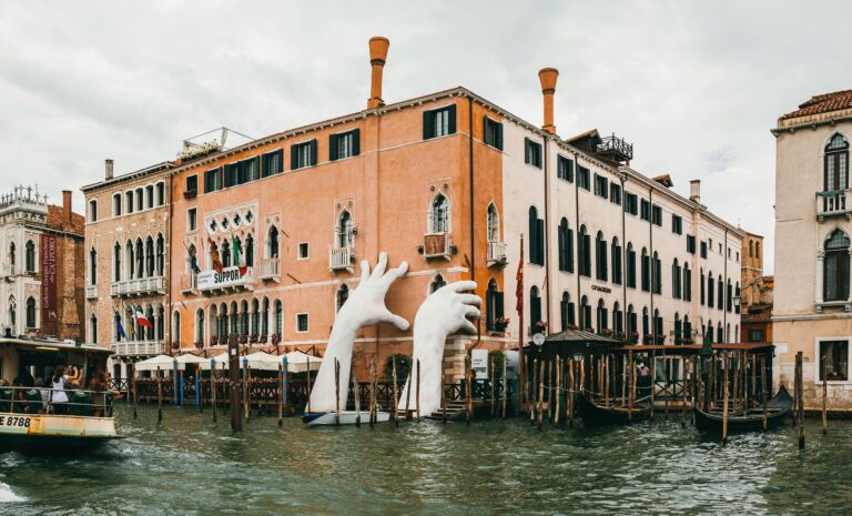 VENICE, ITALY - JULY 02, 2017: Support by Lorenzo Quinn. Gigantic hands rise from water to support the Ca’ Sagredo Hotel, a statement of the impact of climate change and rising sea levels.; Shutterstock ID 1030026829; purchase_order: -; job: -; client: -; other: -
