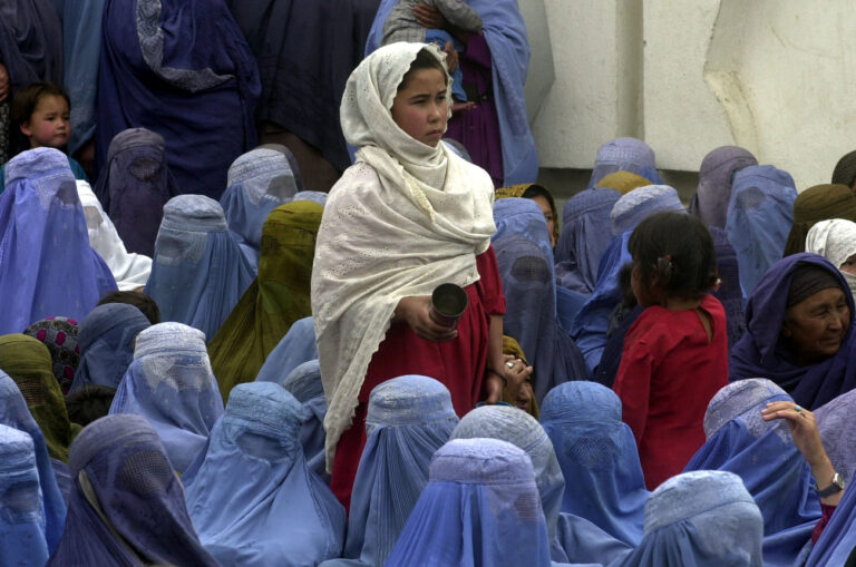 A young woman offers water to women in Kabul, Afghanistan, Sunday, May 26, 2002, who are participating in the selection process for the upcoming loya jirga grand council meeting. The meeting, which will choose a new Afghan government, is required by a U.N.-brokered agreement to have a certain proportion of female delegates. (KEYSTONE/AP Photo/Darko Bandic)