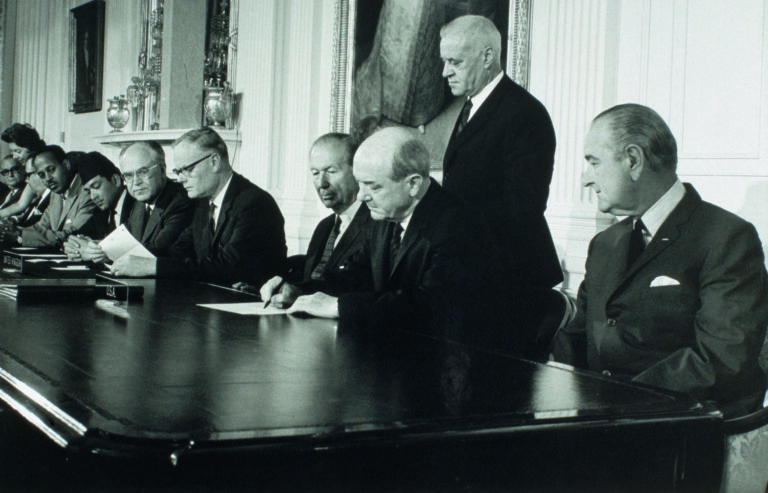 President Johnson looks on as Secretary of State Dean Rusk signs the treaty for the Non-Proliferation of Nuclear Weapons. (Photo by © CORBIS/Corbis via Getty Images)