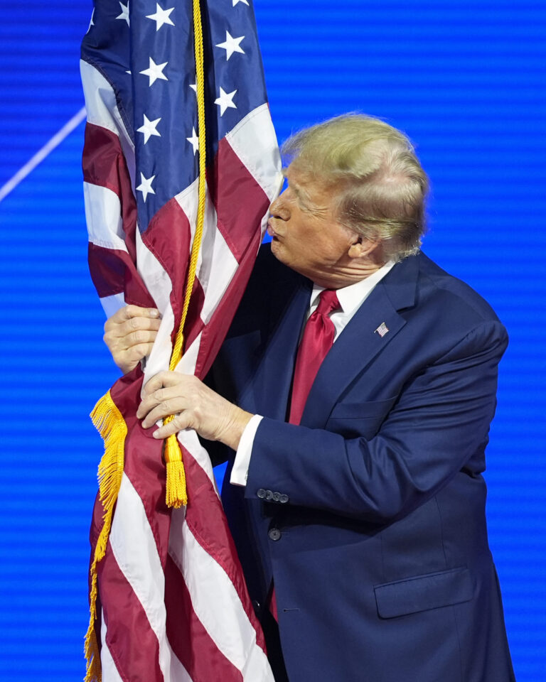Republican presidential candidate former President Donald Trump hugs and kisses the American flag as he speaks at the Conservative Political Action Conference, CPAC 2024, at National Harbor, in Oxon Hill, Md., Saturday, Feb. 24, 2024. (AP Photo/Alex Brandon)