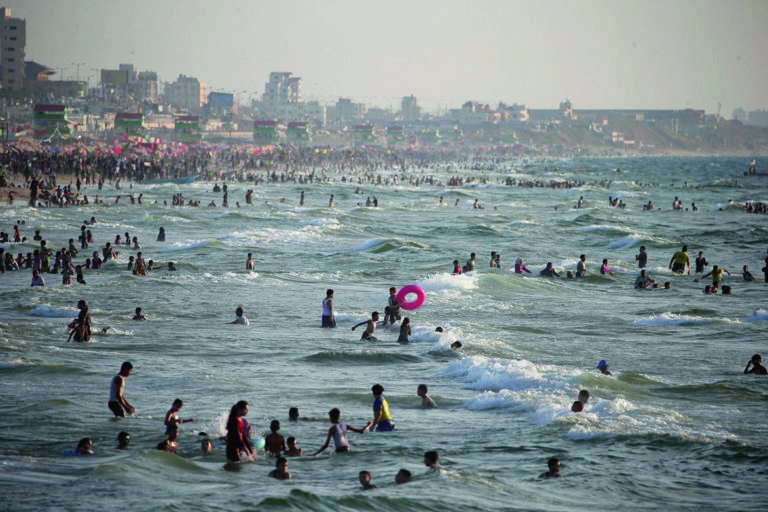 epa10820685 People spend time at Gaza beach, in Gaza Strip, 25 August 2023. EPA/MOHAMMED SABER