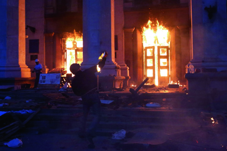A protester throws a petrol bomb at the trade union building in Odessa May 2, 2014. At least 38 people were killed in a fire on Friday in the trade union building in the centre of Ukraine's southern port city of Odessa, regional police said.  REUTERS/Yevgeny Volokin (UKRAINE - Tags: POLITICS CIVIL UNREST) - GM1EA5309GV01